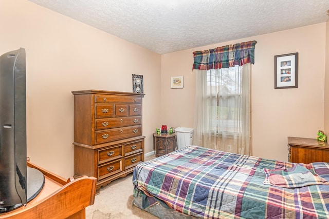 bedroom featuring a textured ceiling and light colored carpet