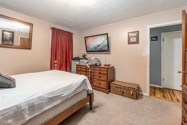 bedroom with light carpet and a textured ceiling