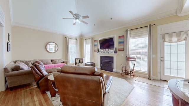 living room with lofted ceiling, light wood-type flooring, ceiling fan, and ornamental molding