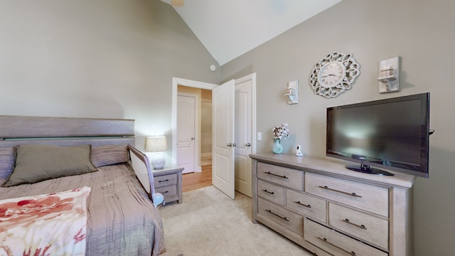 bedroom featuring high vaulted ceiling and light colored carpet