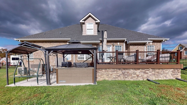 back of property featuring a gazebo, a yard, and a deck