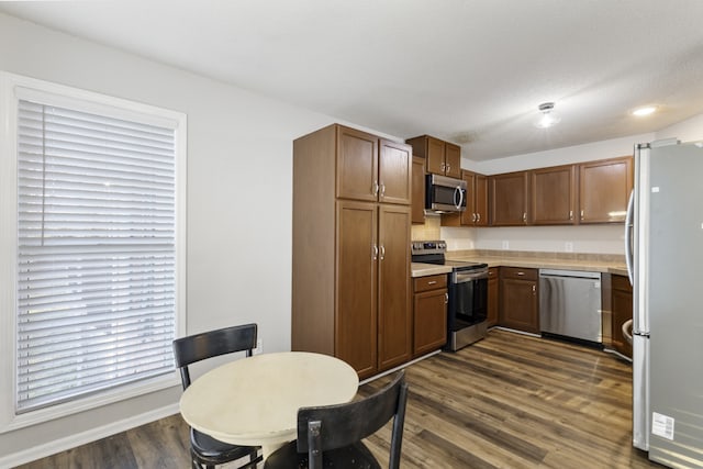 kitchen featuring a textured ceiling, dark hardwood / wood-style floors, and appliances with stainless steel finishes