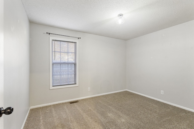 carpeted spare room with a textured ceiling