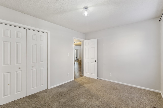 unfurnished bedroom with a closet, carpet, and a textured ceiling