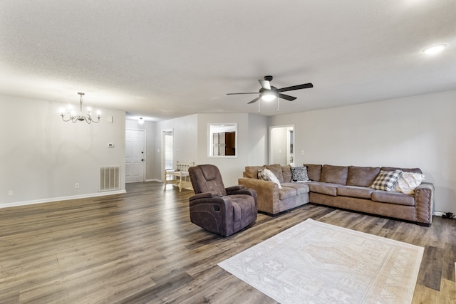 living room featuring wood-type flooring, ceiling fan with notable chandelier, and a textured ceiling