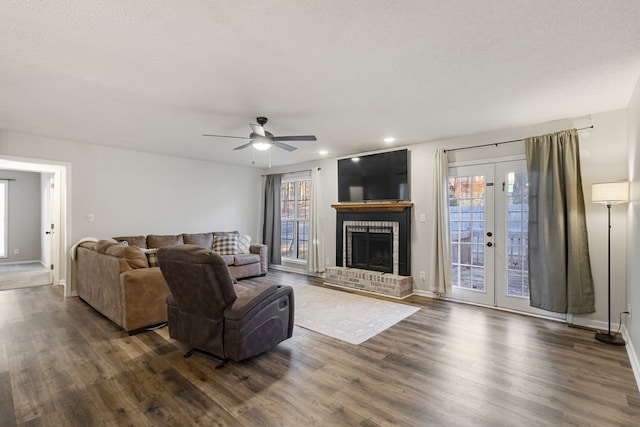 living room featuring a wealth of natural light, ceiling fan, and dark wood-type flooring