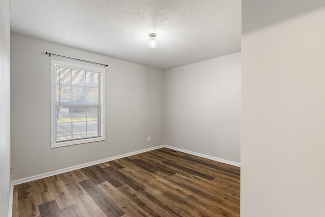 spare room featuring dark hardwood / wood-style flooring and a textured ceiling