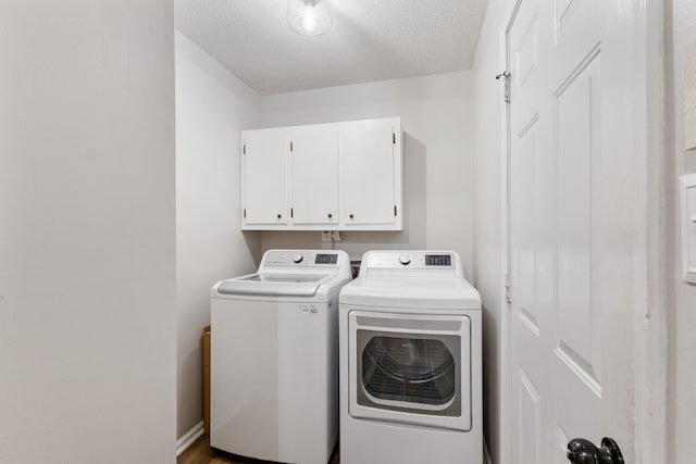 washroom featuring cabinets, separate washer and dryer, and a textured ceiling