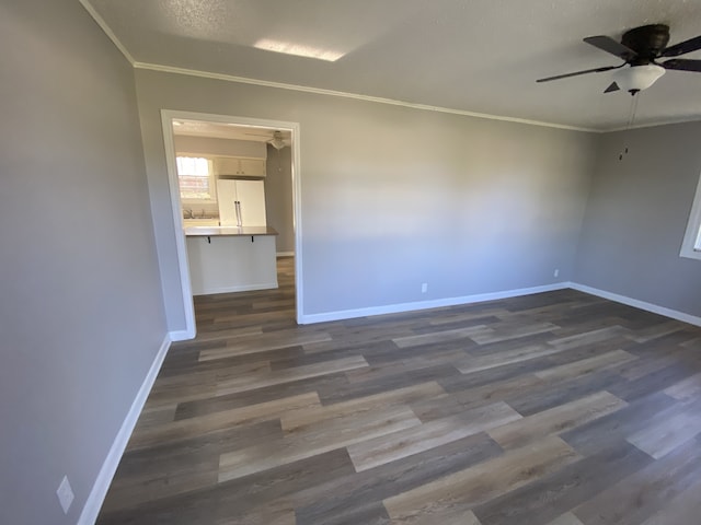 unfurnished room featuring a textured ceiling, dark hardwood / wood-style floors, ceiling fan, and ornamental molding