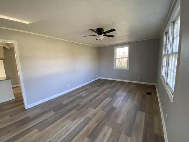 spare room featuring a textured ceiling, dark hardwood / wood-style flooring, ceiling fan, and crown molding