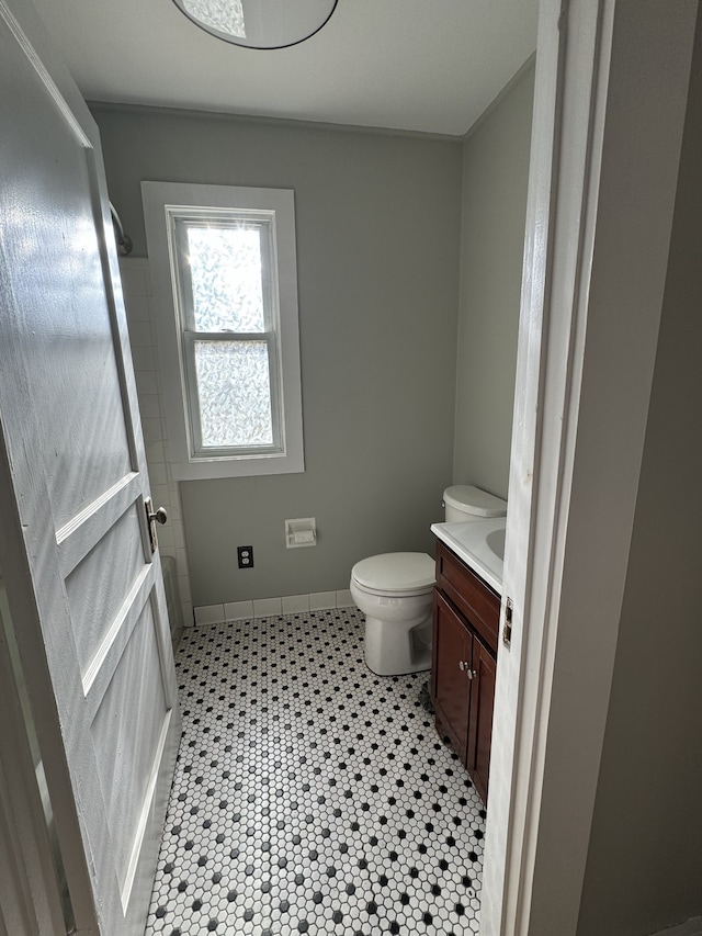 bathroom with toilet, baseboards, and vanity