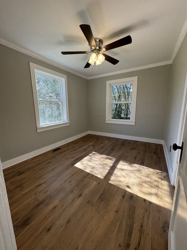 unfurnished room with ornamental molding, visible vents, and dark wood-style floors