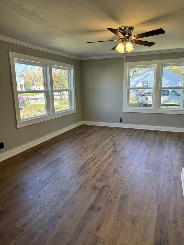 spare room featuring a ceiling fan, baseboards, ornamental molding, and dark wood-style flooring