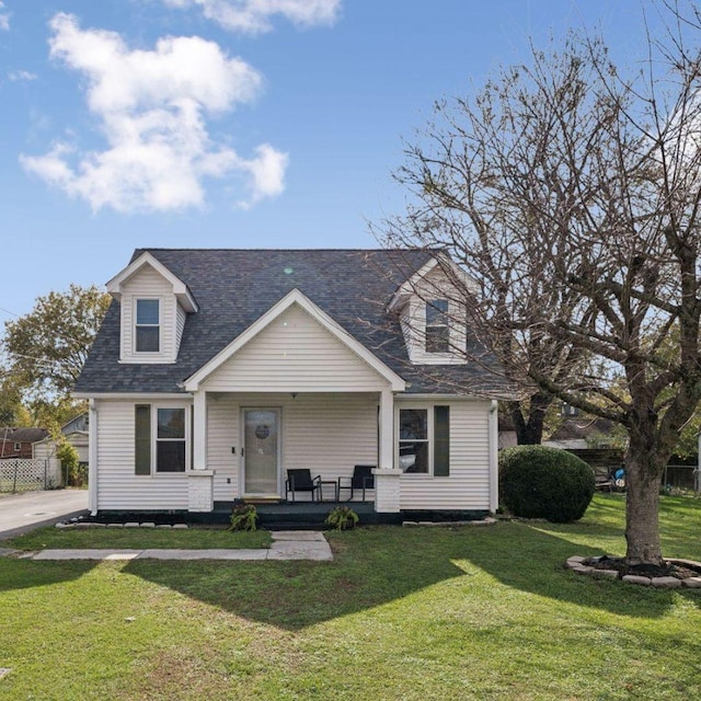 cape cod house featuring covered porch and a front yard