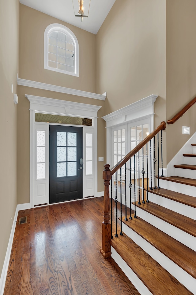 foyer featuring a towering ceiling and dark hardwood / wood-style floors