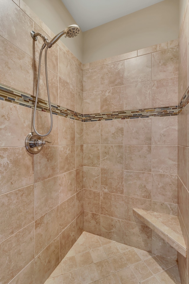 bathroom featuring tiled shower and tile patterned floors