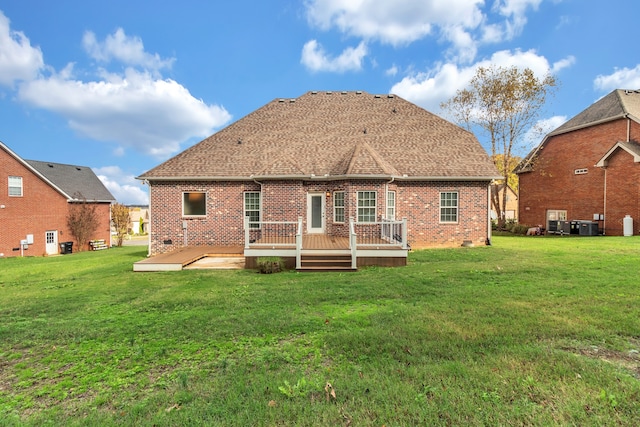 back of property with a wooden deck, a yard, and central AC unit