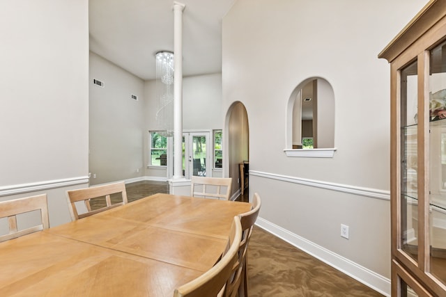 dining space with decorative columns and a chandelier