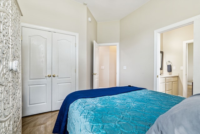 bedroom featuring hardwood / wood-style flooring, ensuite bathroom, and a closet