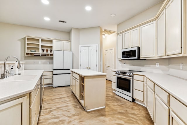 kitchen with sink, a kitchen island, cream cabinetry, and appliances with stainless steel finishes