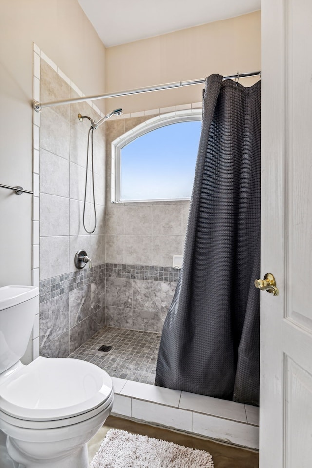 bathroom with curtained shower and toilet