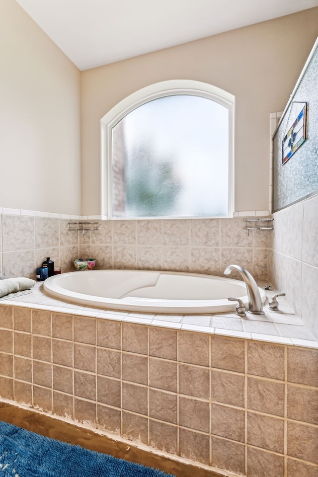 bathroom with hardwood / wood-style floors and a relaxing tiled tub