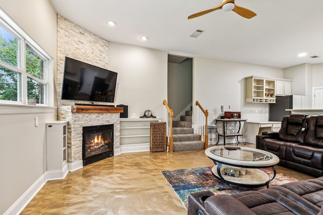 living room with a fireplace and ceiling fan