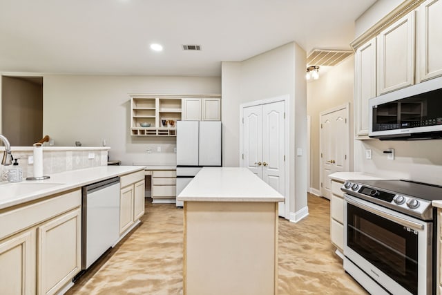 kitchen featuring a center island, sink, appliances with stainless steel finishes, and cream cabinets