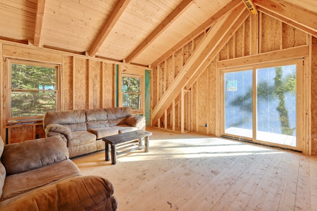 living room with vaulted ceiling with beams, light hardwood / wood-style flooring, and wooden walls