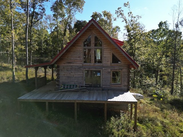 rear view of property featuring a wooden deck