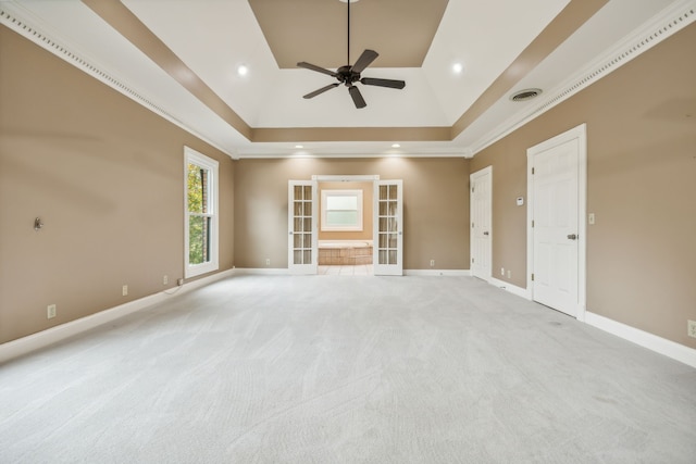 carpeted empty room with ceiling fan, crown molding, a tray ceiling, and french doors