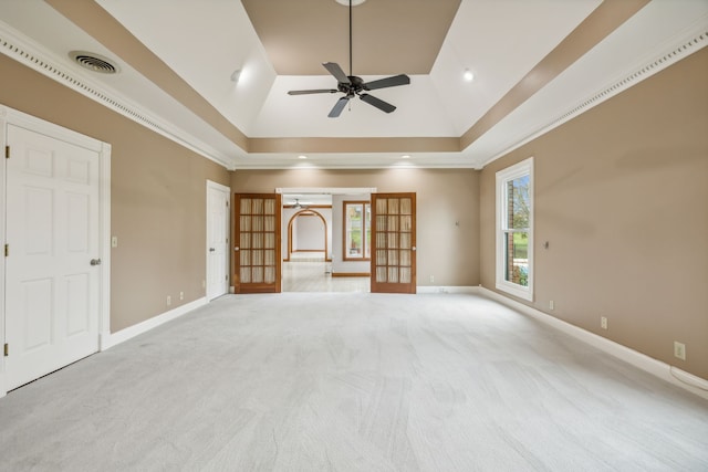 unfurnished living room featuring ceiling fan, light colored carpet, and a tray ceiling