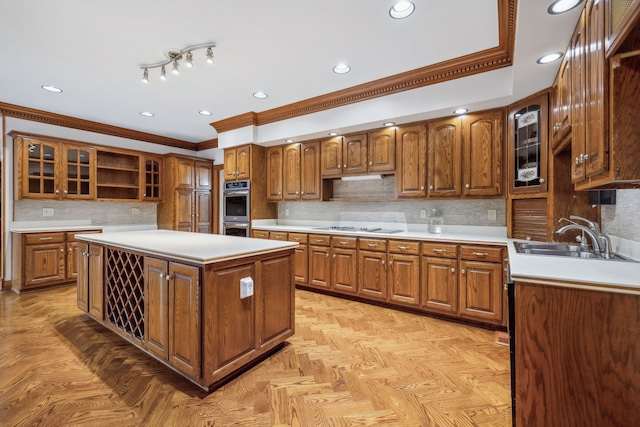 kitchen featuring ornamental molding, cooktop, stainless steel double oven, sink, and a kitchen island