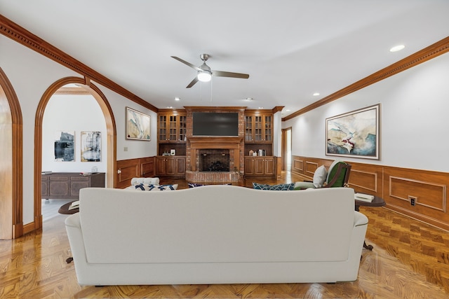 living room featuring light parquet floors, a brick fireplace, and ornamental molding