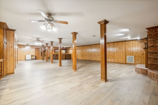 basement with light hardwood / wood-style flooring, ceiling fan, ornamental molding, and wood walls