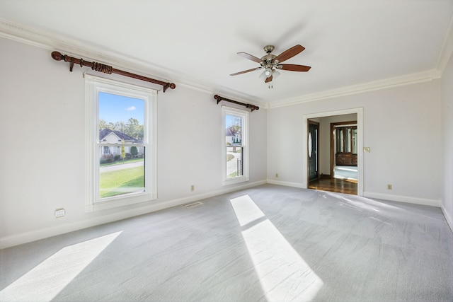 spare room featuring ceiling fan, light colored carpet, and ornamental molding