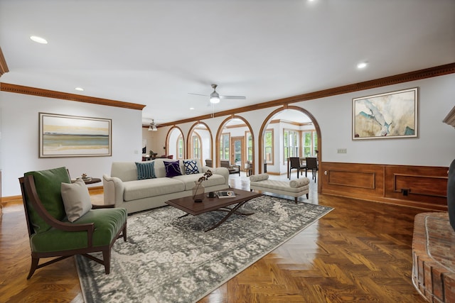 living room featuring dark parquet floors, ceiling fan, and ornamental molding