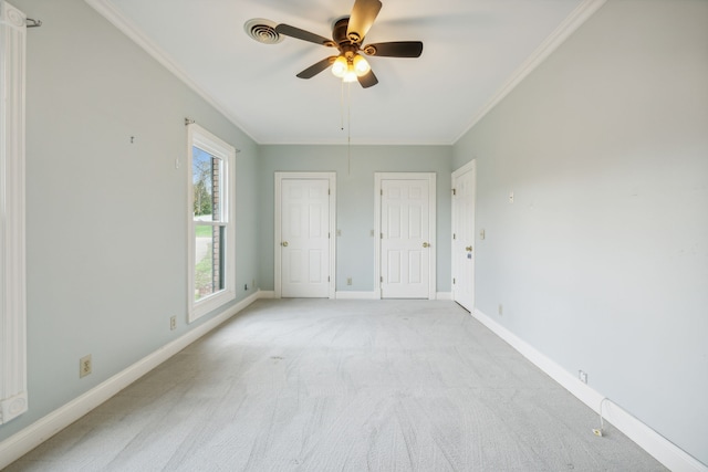 carpeted spare room featuring ceiling fan and ornamental molding