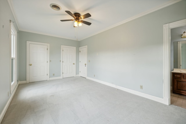 unfurnished bedroom with light carpet, ornamental molding, ceiling fan, connected bathroom, and multiple closets