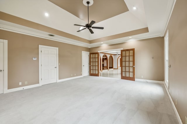 unfurnished room with ceiling fan, ornamental molding, light carpet, and a tray ceiling