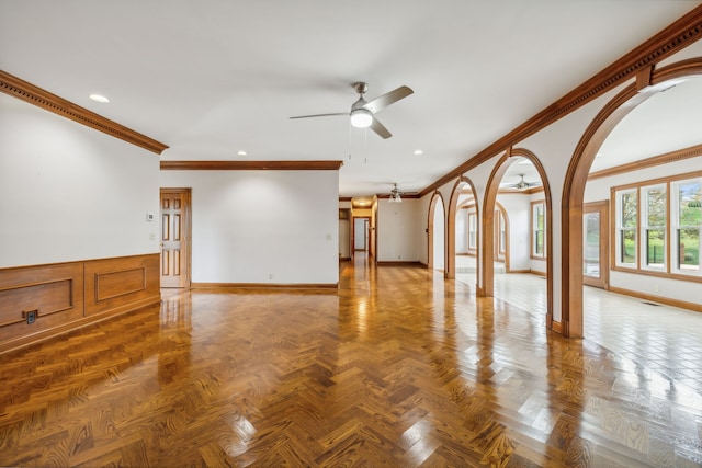 spare room featuring ceiling fan, ornamental molding, and parquet flooring