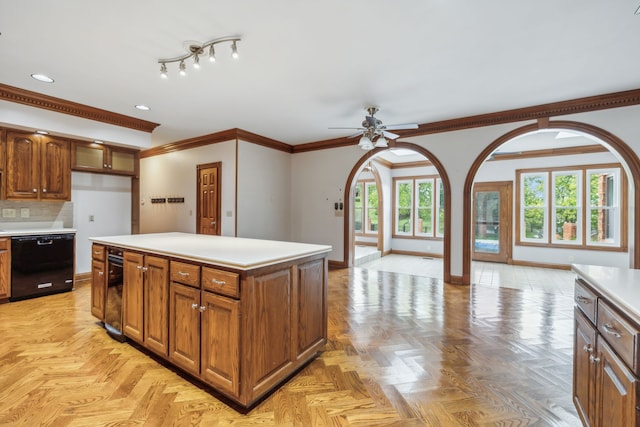 kitchen featuring ceiling fan, a kitchen island, black dishwasher, light parquet flooring, and ornamental molding