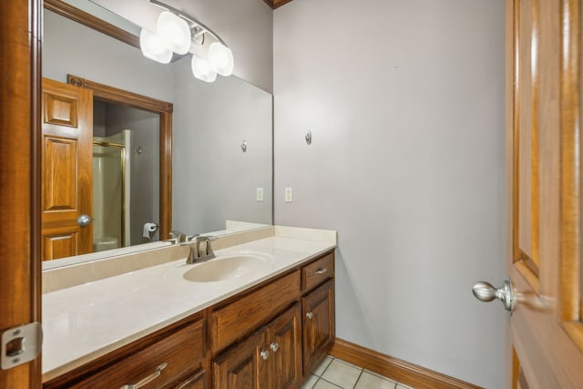 bathroom featuring tile patterned flooring, vanity, toilet, and walk in shower