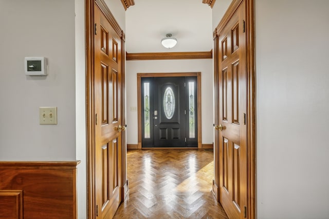 doorway to outside featuring light parquet floors and crown molding