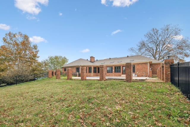 back of house featuring a patio area and a yard