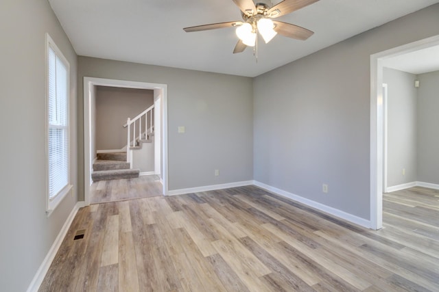 unfurnished room featuring a wealth of natural light, light hardwood / wood-style flooring, and ceiling fan