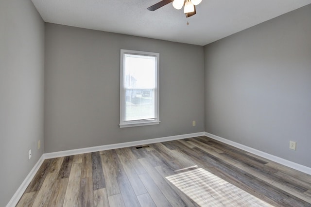 empty room with hardwood / wood-style flooring and ceiling fan