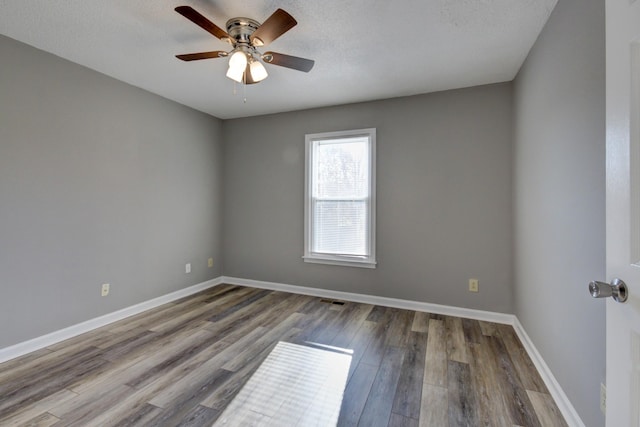 spare room with hardwood / wood-style floors, ceiling fan, and a textured ceiling