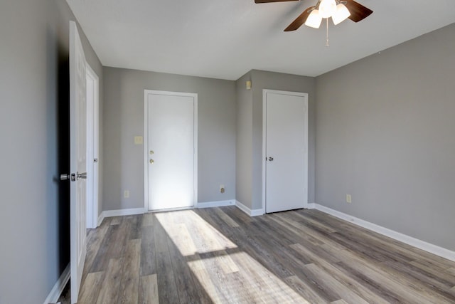 unfurnished bedroom with ceiling fan and wood-type flooring