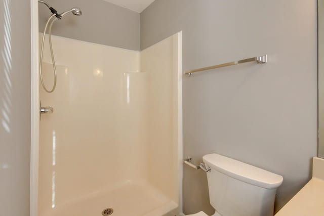 bathroom featuring a shower and toilet